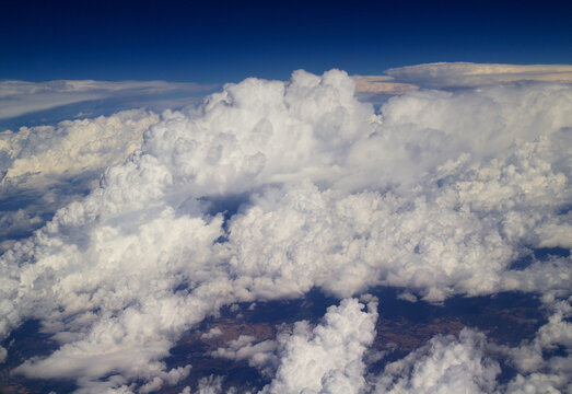 Aerial View Above Fluffy Cumulus Clouds Under Deep Blue Sky