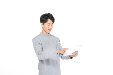 Young Asian man using tablet on white background © LaDieuNgoc