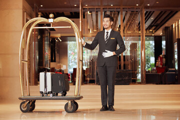 Hotel concierge with luggage cart in luxury hotel lobby © HuaThuy