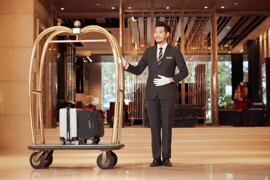 Hotel concierge with luggage cart in luxury hotel lobby