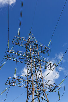 Electricity Transmission Pylon and Power Lines Against Cloudy Blue Sky