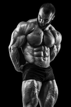 Bodybuilder man on the black background. Strong male naked torso abs