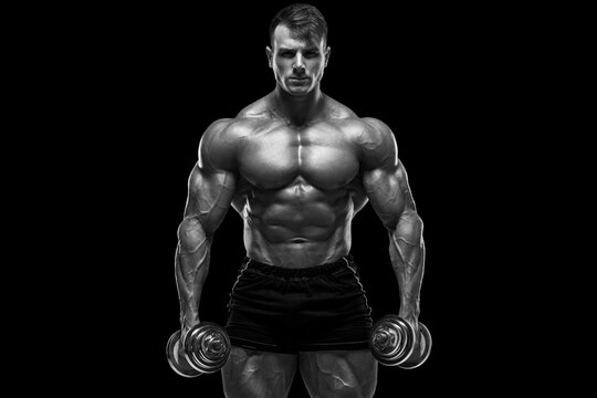 Muscular man with dumbbells on the black background. Strong male naked torso abs