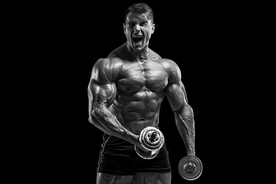 Muscular man working out isolated on black background. Strong male naked torso abs