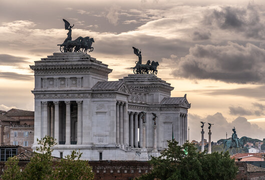 A view of Rome at sunset. A monument in Rome with beautiful clouds and a quadriga. Venice Square in Rome.