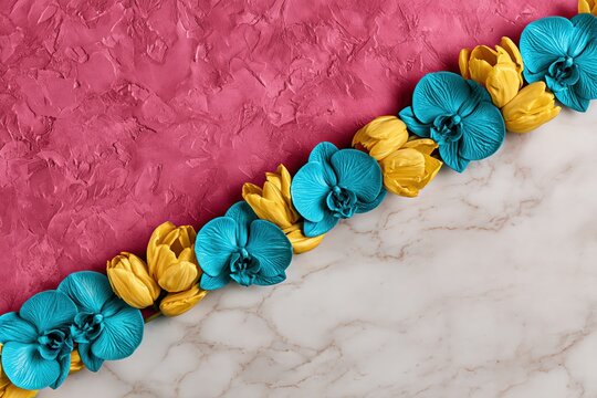 Blue orchids and yellow tulips floral border on pink marble background
