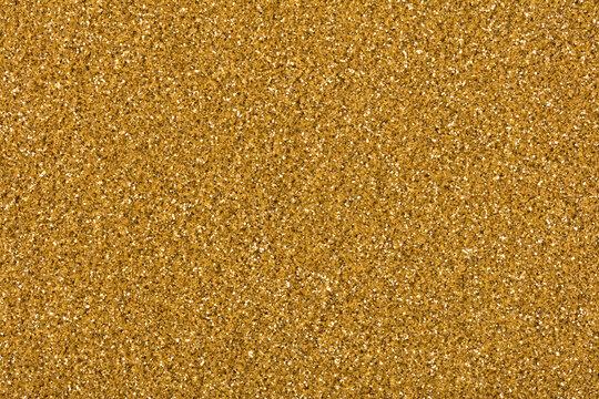 Gold glitter texture with sparkling shiny particles close up