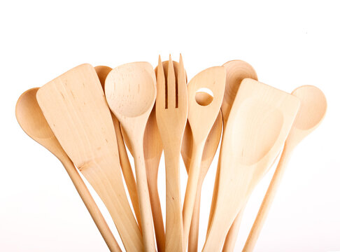 Set of wooden kitchen utensils fanned out on white background