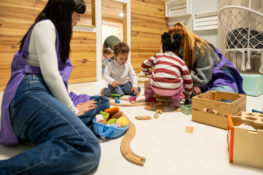 Toddlers and teachers engaging in creative play with educational toys in a bright classroom
