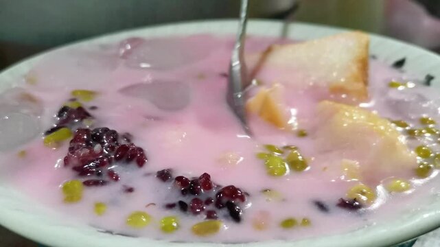 Traditional Indonesian es campur dessert with mung beans and bread in bowl