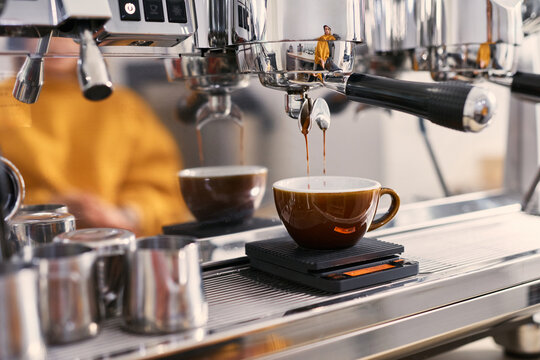 Making fresh espresso drink into a cup on coffee machine