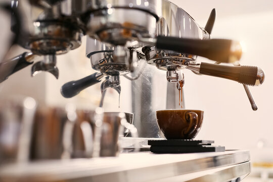 Making fresh espresso drink into a cup on coffee machine