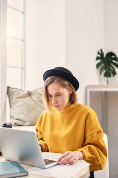 Blonde young woman working on laptop, close up
