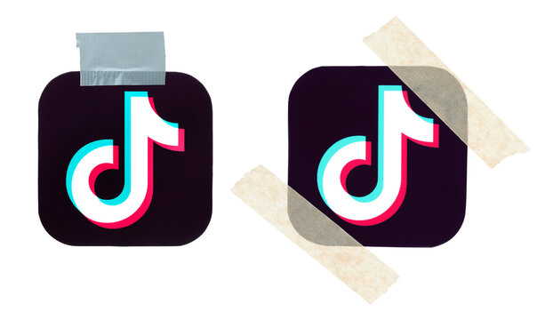 Set of paper TikTok social media icons attached with adhesive tape. Concept of unstable digital platform, temporary fix, content moderation, fragile online presence and short video communication