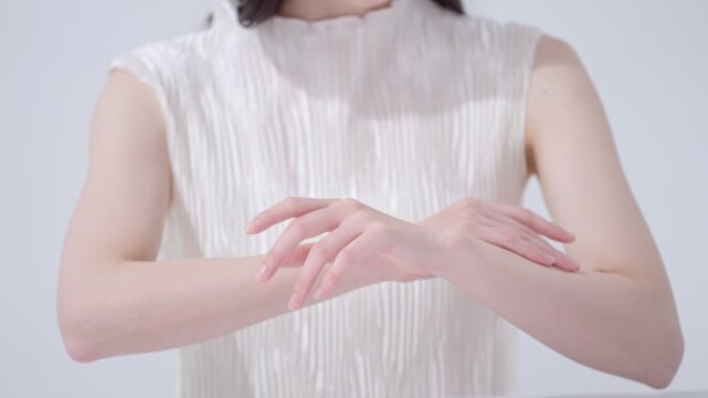 腕に日焼け止めを塗る女性