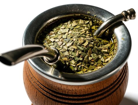 Traditional yerba mate drink in wooden cup with metal bombilla straw. Dried green herb infusion prepared in calabash for sipping. South American caffeine beverage.
