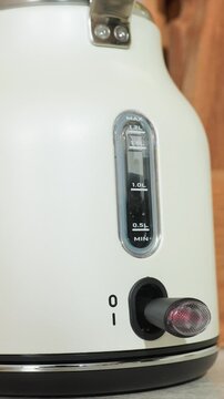 Device showing illuminated spout area near bottom front. Red indicator stays lit suggesting active heating. Close up view emphasizes bottom half including red light spout