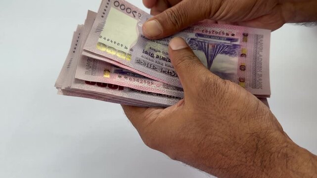 Hands Counting Bangladeshi Taka Banknotes on White Background in 4K. Bangladeshi Taka