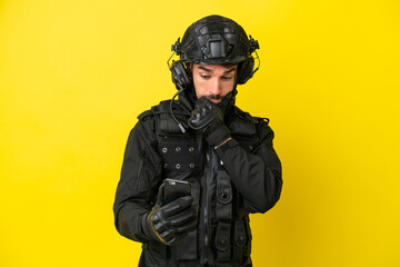 Naklejka premium SWAT caucasian man isolated on yellow background thinking and sending a message
