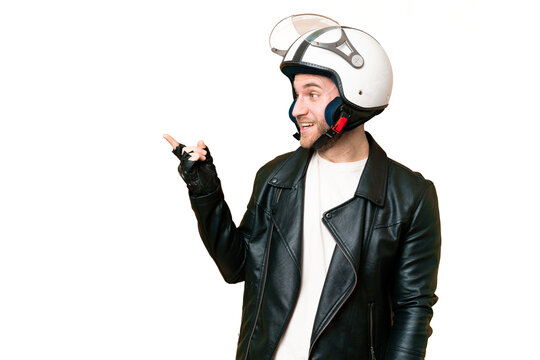 Young handsome blonde man with a motorcycle helmet over isolated chroma key background pointing finger to the side and presenting a product