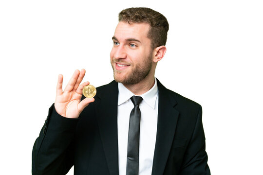 Young business blonde man holding a Bitcoin over isolated chroma key background looking to the side and smiling