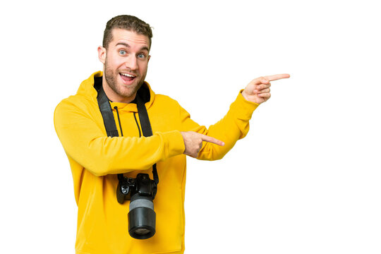 Young photographer man over isolated chroma key background surprised and pointing side