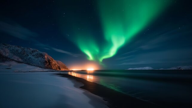 Aurora Borealis Over Icy Shoreline: Vibrant green aurora borealis dances across the dark night sky, casting an ethereal glow over a snow-covered beach and calm sea.