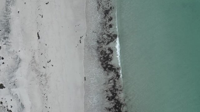 Static aerial view of white sand beach with gentle turquoise waves rolling in, North Uist and Berneray, Scotland
