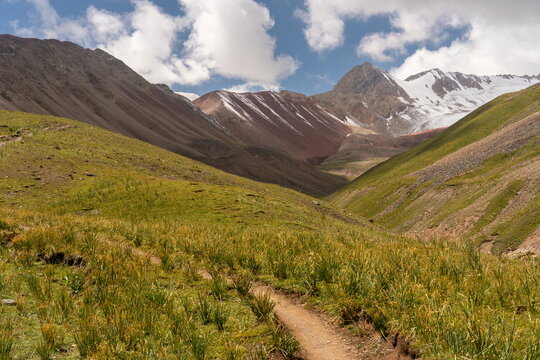 Trail winds toward Travelers Pass on the edge of Wild Onion Field, route to Lenin Camp 1 in Kyrgyzstan