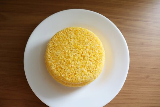 Brazilian couscous on a wooden background. Couscous (Cuscuz, in Portuguese) is a typical northeastern Brazil breakfast.
