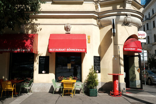 Vienna, Austria - August 24, 2025: Traditional restaurant Bohmerwald facade with red awnings and outdoor seating.