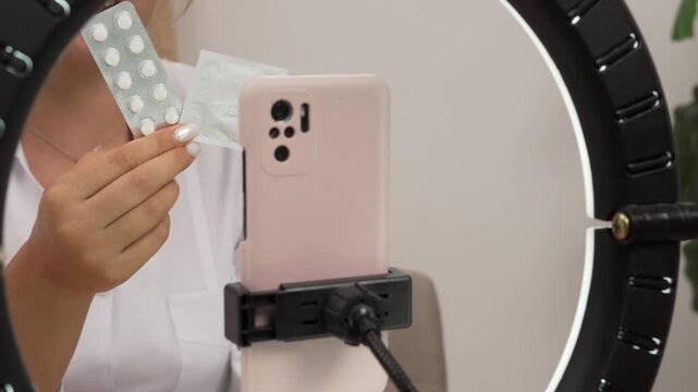 A gynecologist holds a pill and a condom live online. Comparison of contraceptive methods. Concept of healthcare and medicine.