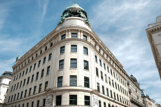 Vienna, Austria - August 18, 2025. Low angle architectural view of the historic Generali building facade, featuring classical design, a rounded corner structure, and a prominent green copper dome.
