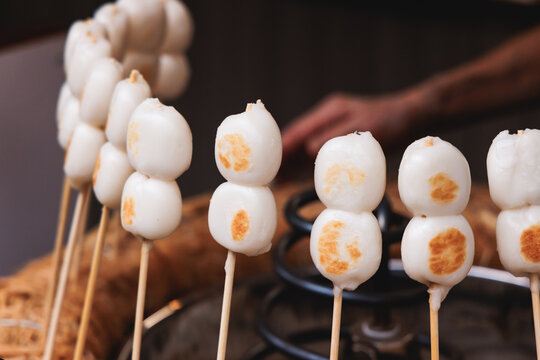 Dango on skewer, Mitarashi dango, traditional Japanese street food, grilled rice cake balls dumplings on wooden sticks, street food festival, Tokyo, Japan, market with local vendor stalls cooking