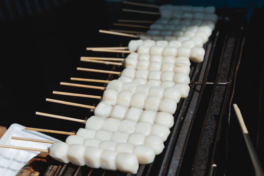 Dango on skewer, Mitarashi dango, traditional Japanese street food, grilled rice cake balls dumplings on wooden sticks, street food festival, Tokyo, Japan, market with local vendor stalls cooking