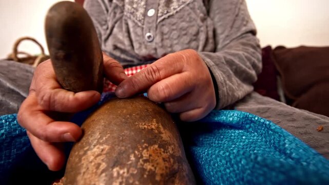 Traditional Moroccan Woman Cracking Argan Nuts by Hand