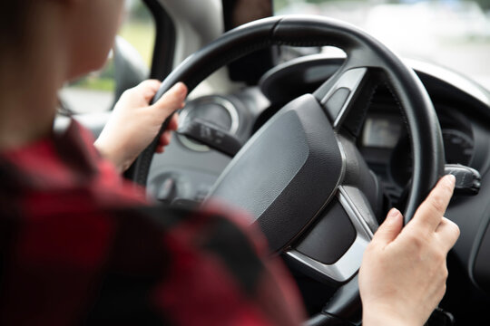 Driver Keeping Both Hands on Steering Wheel for Safe Driving. Shallow depth of field, soft focus and blurred background. Learner driver practices correct hand position and traffic rules in a car
