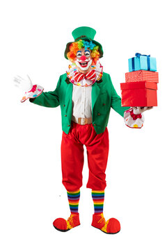 Funny clown with gifts, man entertainer as Joker in a suit and wig, with clown whiteface makeup. Trickster, jester, pantomime, mime, and a professional actor at events, birthday party