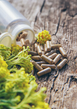 Helichrysum extract in a bottle and capsules. Selective focus.