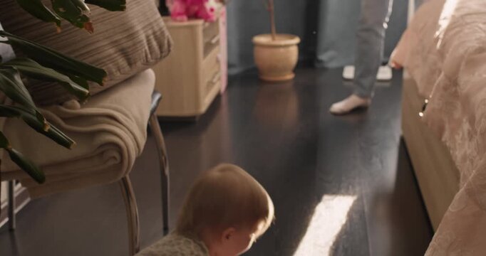 Toddler learning to walk indoors with toy in hand. Early movement, balance and child development milestone