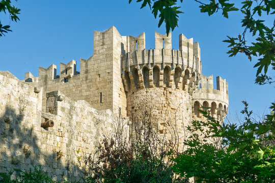 Medieval castle towers of the Palace of the Grand Master in Rhodes framed by green leaves