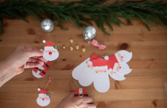 Crafting Christmas decorations with Santa Claus paper cutouts and ornaments