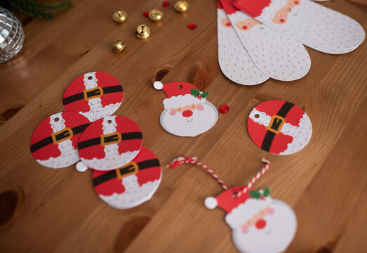 Christmas-themed gift tags and decorations on wooden table surface