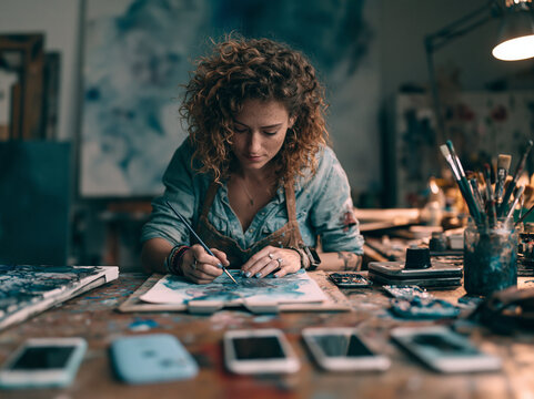 Young Female Artist Painting Artwork in Creative Studio Workspace