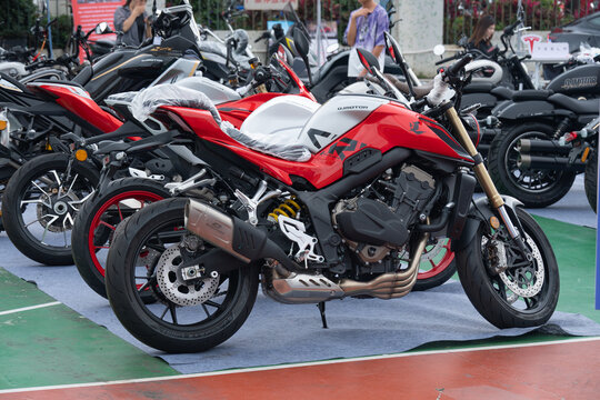 ZhongShan GuangDong China-April 11 2026: QJMOTOR 600RS red silver naked street motorcycle exhibited at outdoor motor show.
