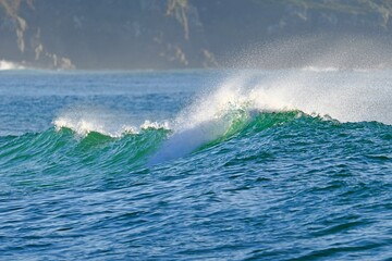 A powerful ocean wave with crystal-clear spray, ready for water sports © GenadiyGM