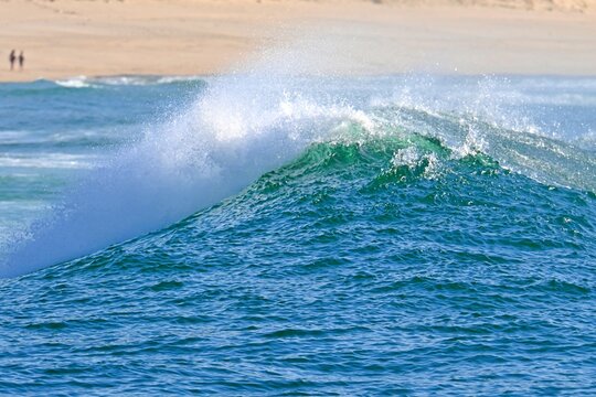 A powerful ocean wave with crystal-clear spray, ready for water sports
