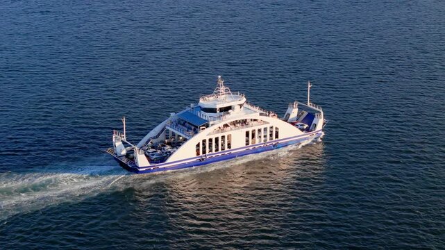 Ferry carrying cars and passengers across calm sea. Vehicle transportation service on short coastal water route