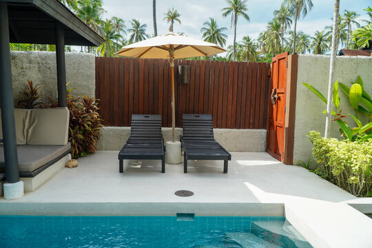 Private pool villa with sun loungers and poolside umbrellas.concept of a pool villa for relaxation.
