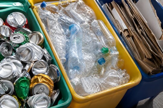 Bins filled with recyclable materials at a waste sorting center in the afternoon